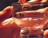 photo of a woman's hand holding a glass of sake