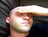 photo of a man holding his forehead with signs of chronic fatigue