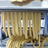 Pasta machine rolling out noodles for cooking pasta