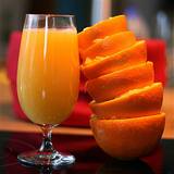 photo of stack of squeezed half oranges with glass of orange juice good source to avoid vitamin deficiency